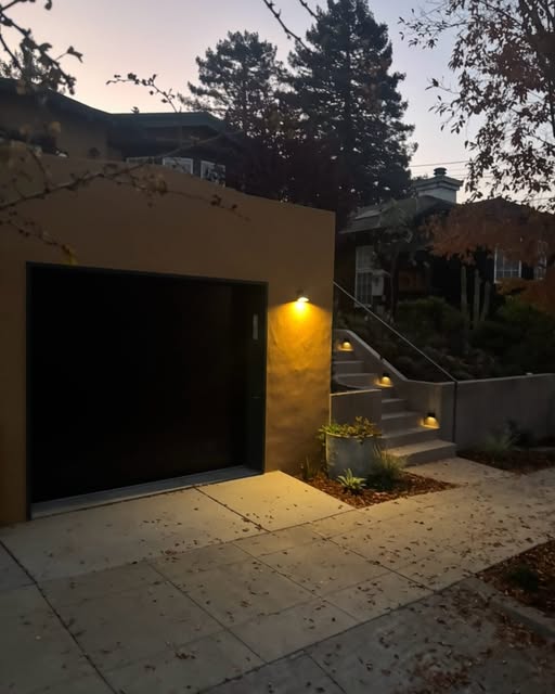 Completed garage terrace and illuminated concrete stairway at dusk